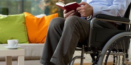 Man in wheelchair reading a book