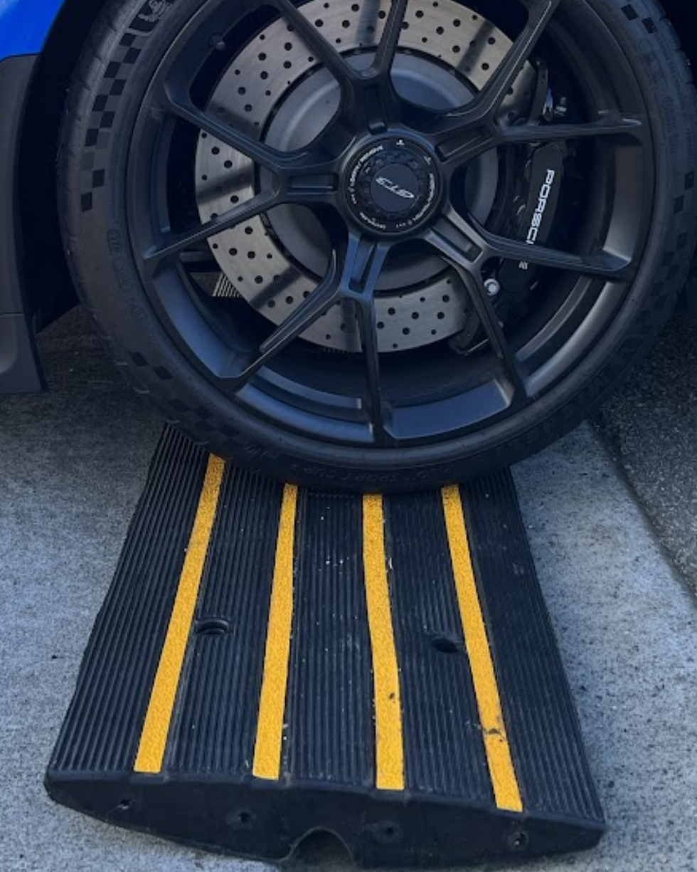 Blue car with black wheels on a kerb rubber ramp