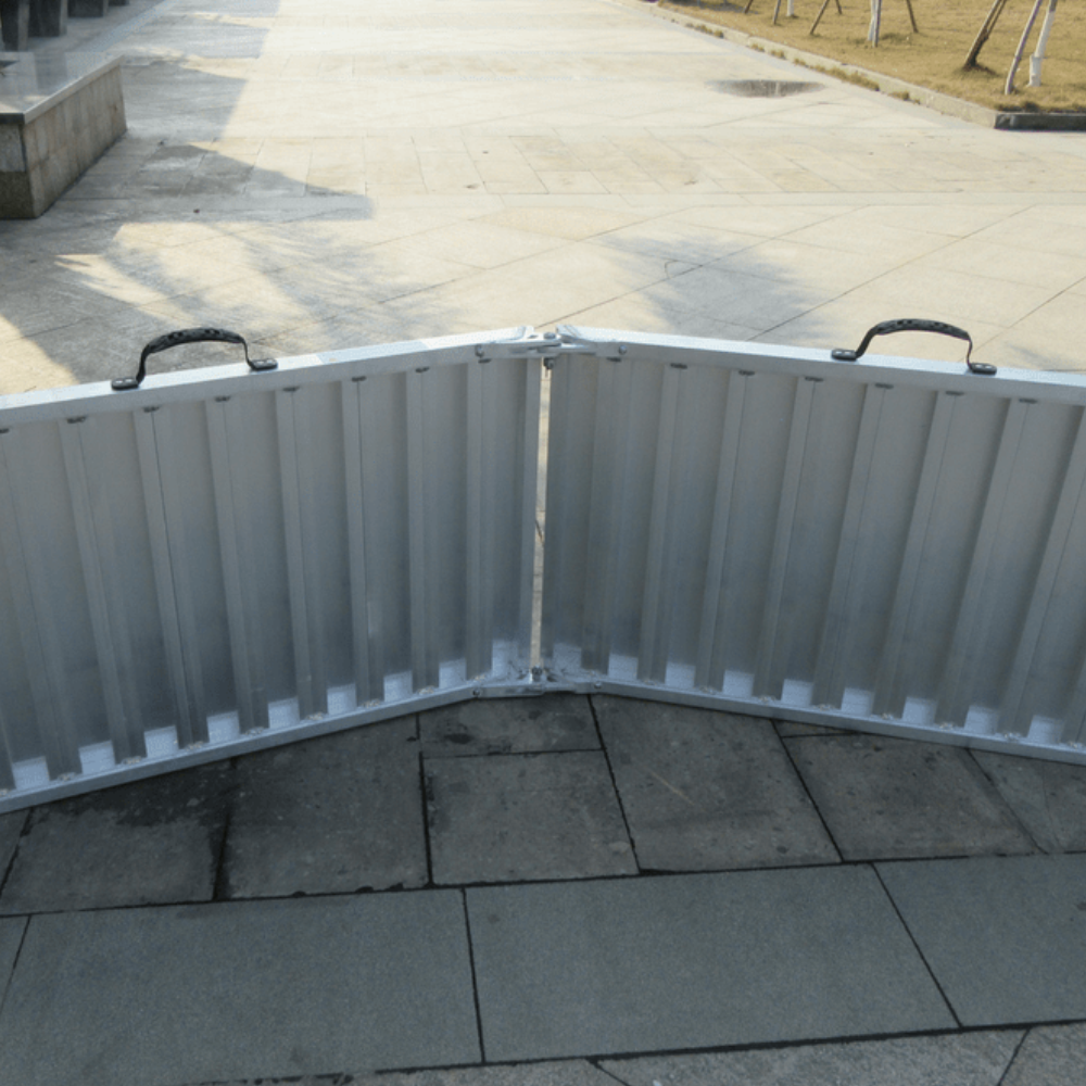 Unfolded ramp with curved ends, placed on paved surface.