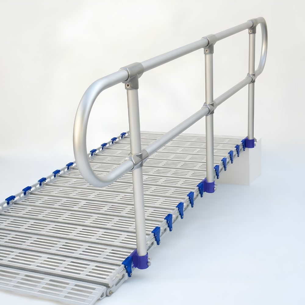 A metal walkway ramp with a slatted floor and silver handrails, shown on a clean white studio background. Blue plastic end caps are visible along the side of the ramp.