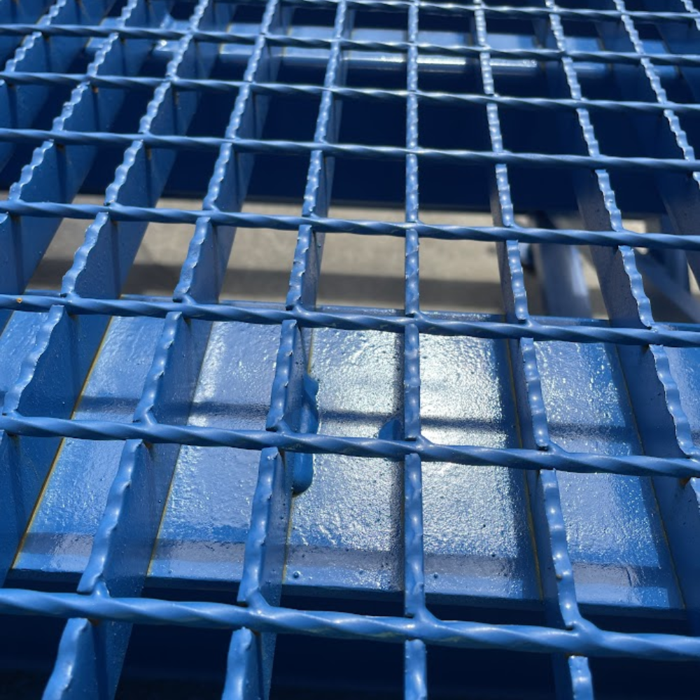 Close-up view of ramp’s blue anti-slip steel grating surface.