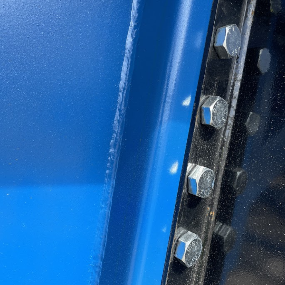 Smooth blue powder-coated steel surface of the ramp side panel.