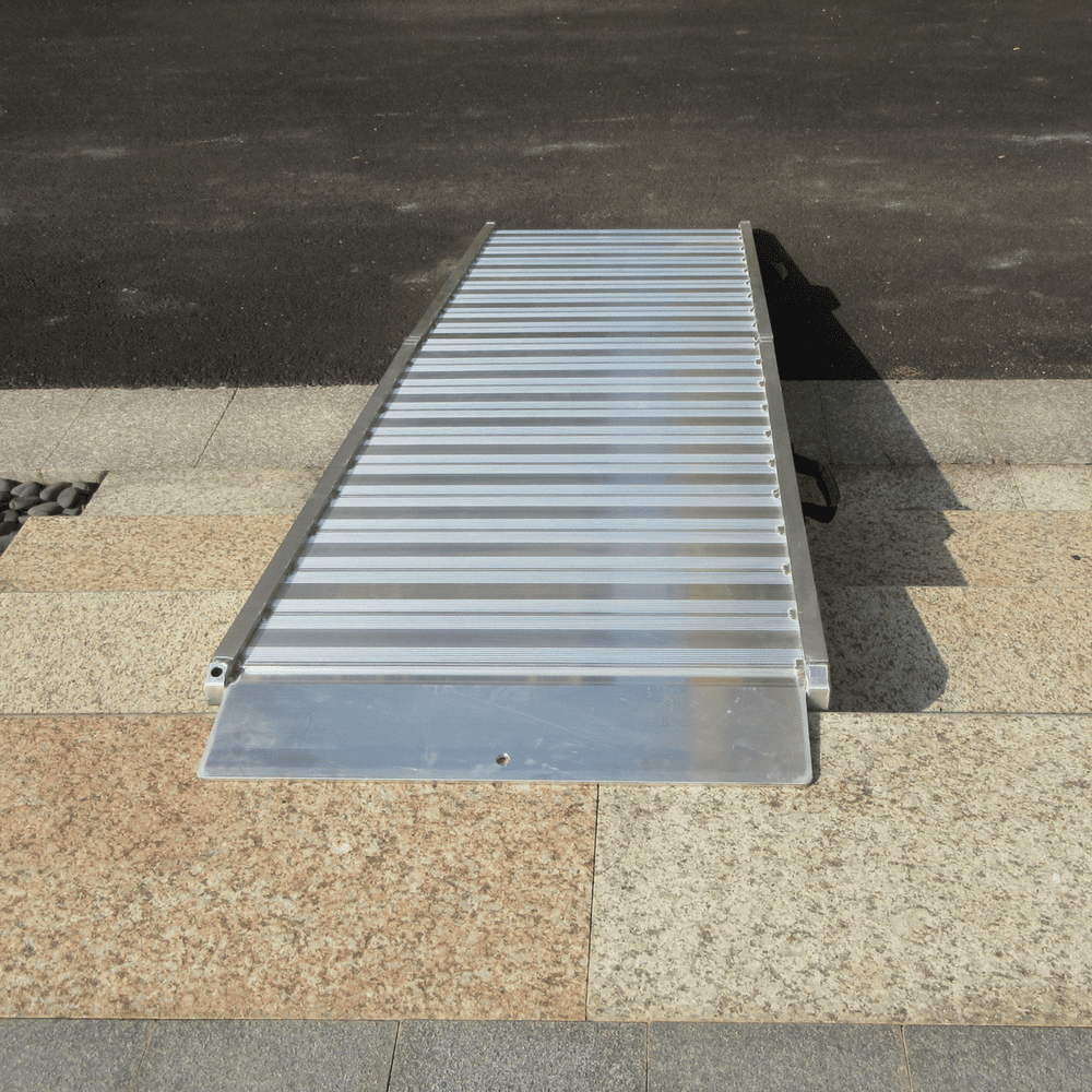 Aluminium ramp set up on kerb edge, partially elevated.