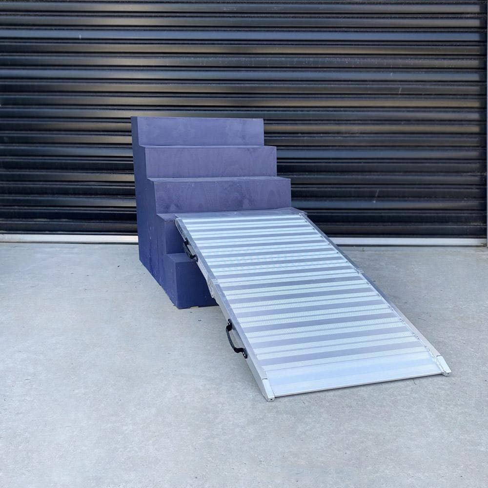 Aluminium ramp in use over a step, compact and portable.
