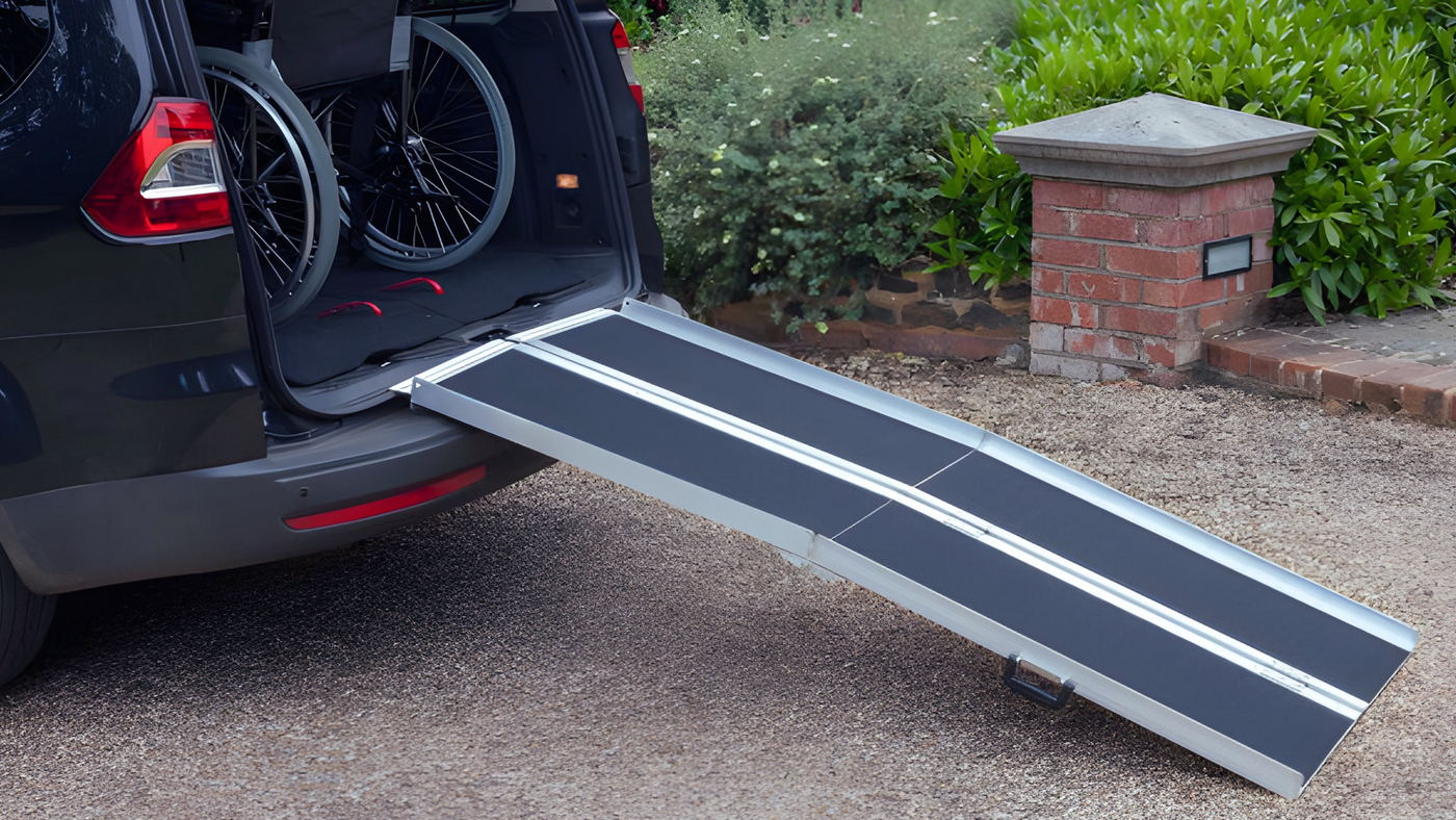 Ramp extended from a vehicle with a garden and brick wall in the background