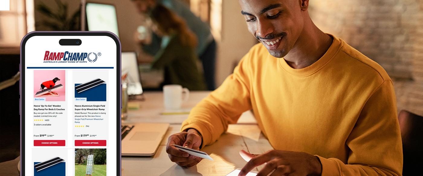 A man in yellow shirt on his computer buying products online from Ramp Champ