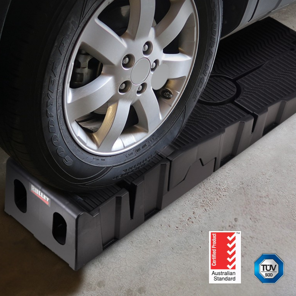 Car wheel on a black rubber mat with TUV logo in the corner