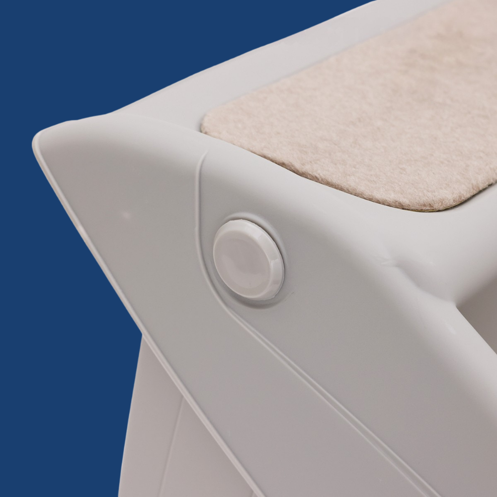 Close-up of a white electronic device with a beige mat on a blue background