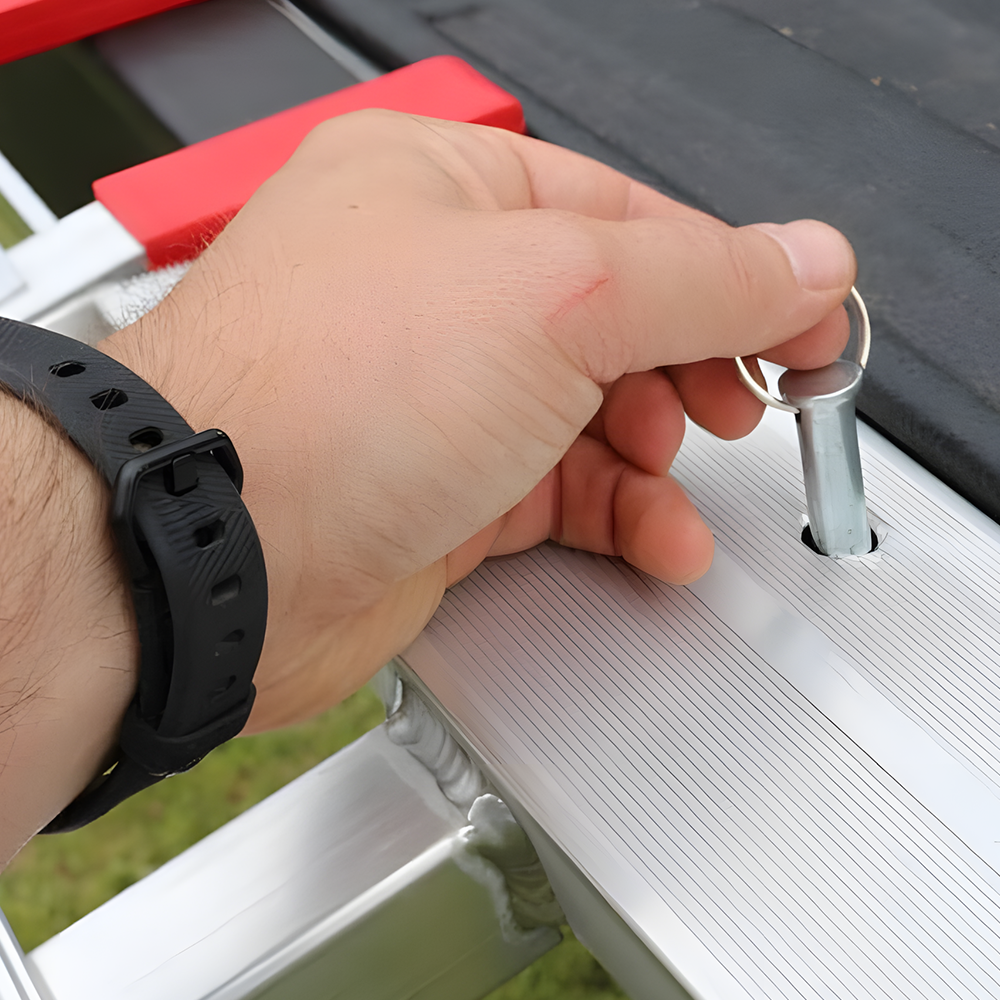 A close-up of the safety locking pin being inserted, showing how to secure the ramp in place during use.
