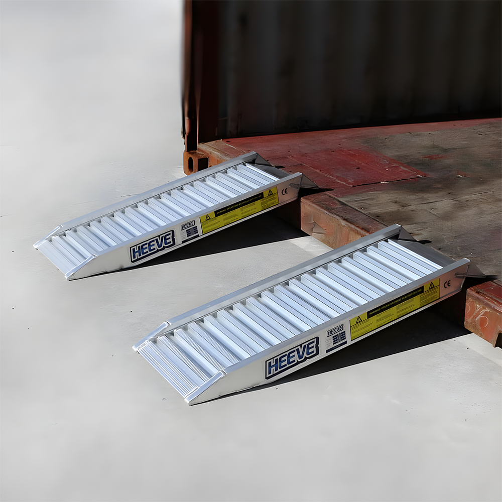 Two Heeve aluminium loading ramps placed at the edge of a platform, designed for easy loading and unloading with raised sides for safety.