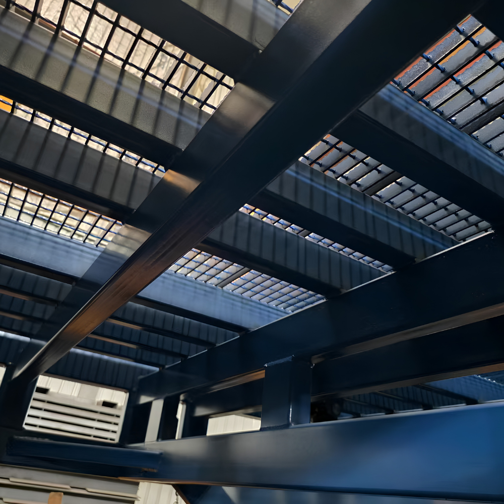 Close-up of large dark steel beams and gridded roof structure inside a warehouse or industrial building.