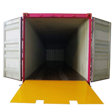 Self-supporting forklift container ramp placed in front of an open shipping container, showing the forklift tyne slots and the anti-skid surface.