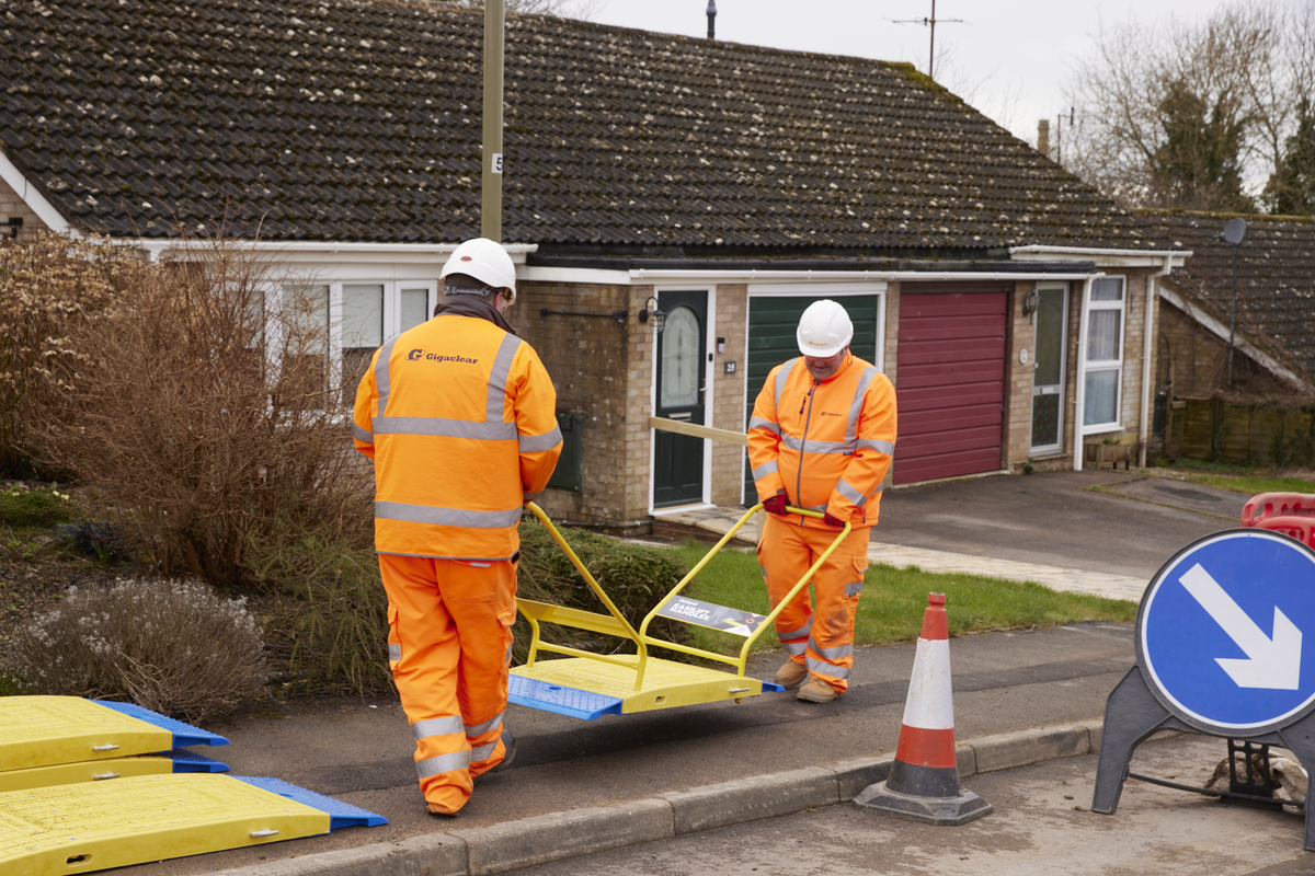 Two workers carrying a LowPro 15/05 road plate with EasiLift handles