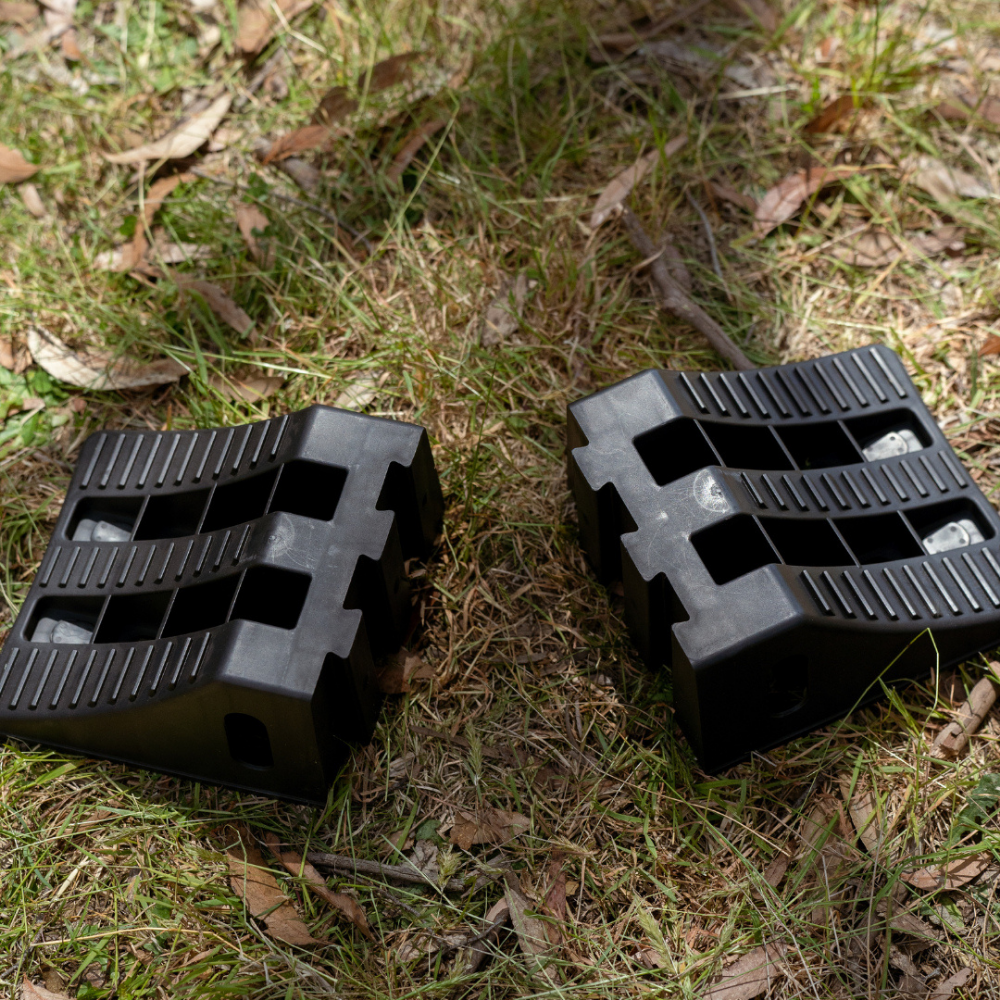 Two black plastic rollers on a grassy ground