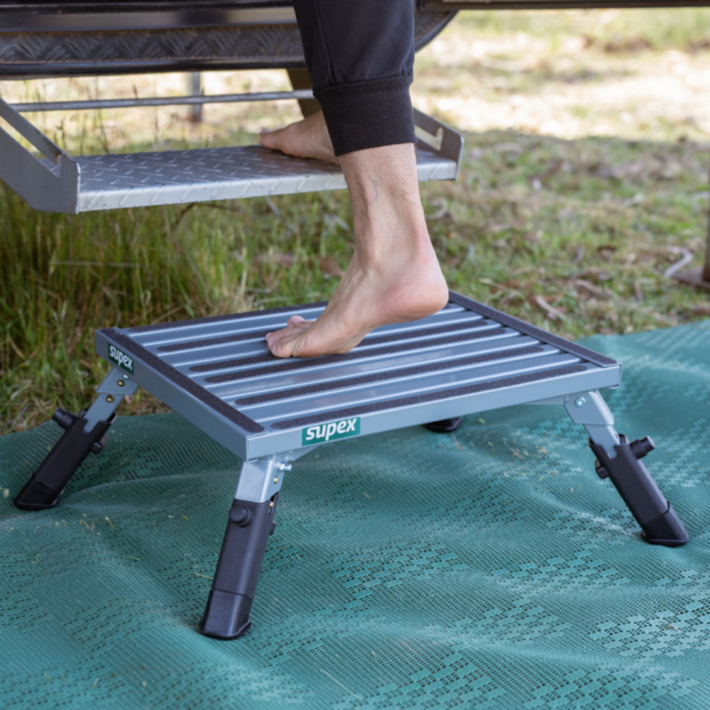 Person using a portable step platform on grass