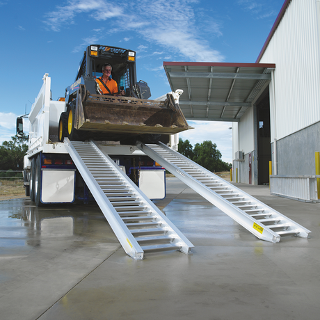 man driving the backhoe on the ramp