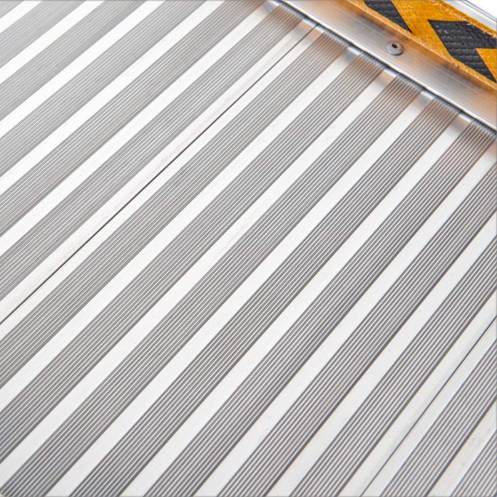 Macro view of the aluminium anti-slip surface, showing parallel grooves for traction.