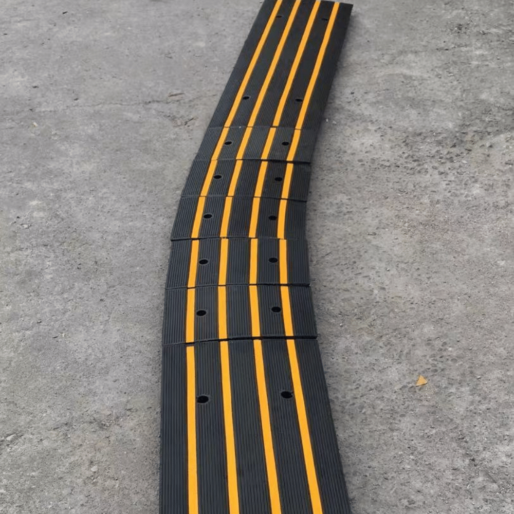 Close-up of a modular black ramp with yellow stripes on concrete floor