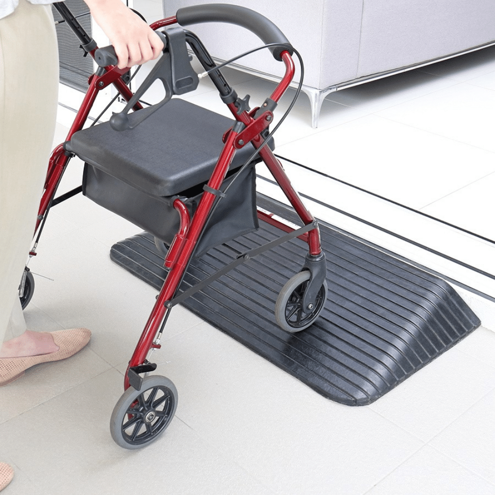 woman pushing a wheeled equipment on the black rubber ramp on the doorway