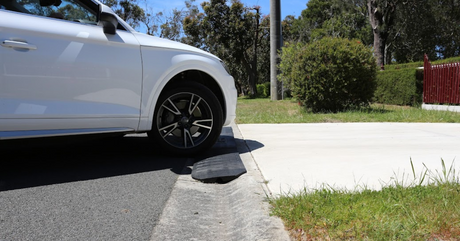 WHite car approaching a driveway with installed rubber kerb ramp