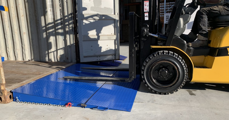 Image of a forklift entering a shipping container using a container ramp for efficient loading and unloading of cargo