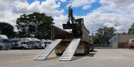 Image of an excavator loading a Heeve excavator ramp attached on a truck