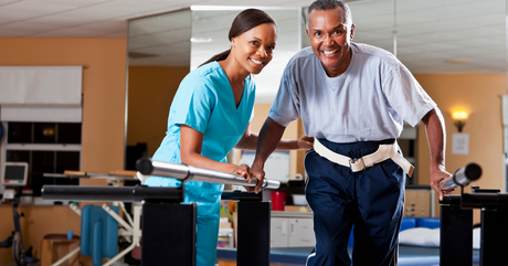 Woman assisting a man undergoing physical therapy 