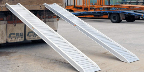 pair of loading ramps attached to a vehicle in a construction site