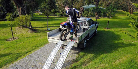 motorcycle rider and a bike on trailer truck with ramp