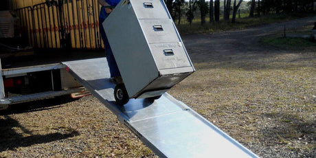 a person unloading a piece of furniture using a ramp