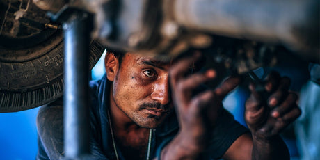 auto mechanic doing repair on a raised vehicle