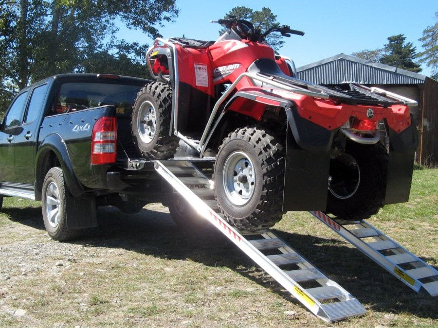 ATV driven up a pair of Sureweld rigid one-piece aluminium loading ramps onto a ute tray