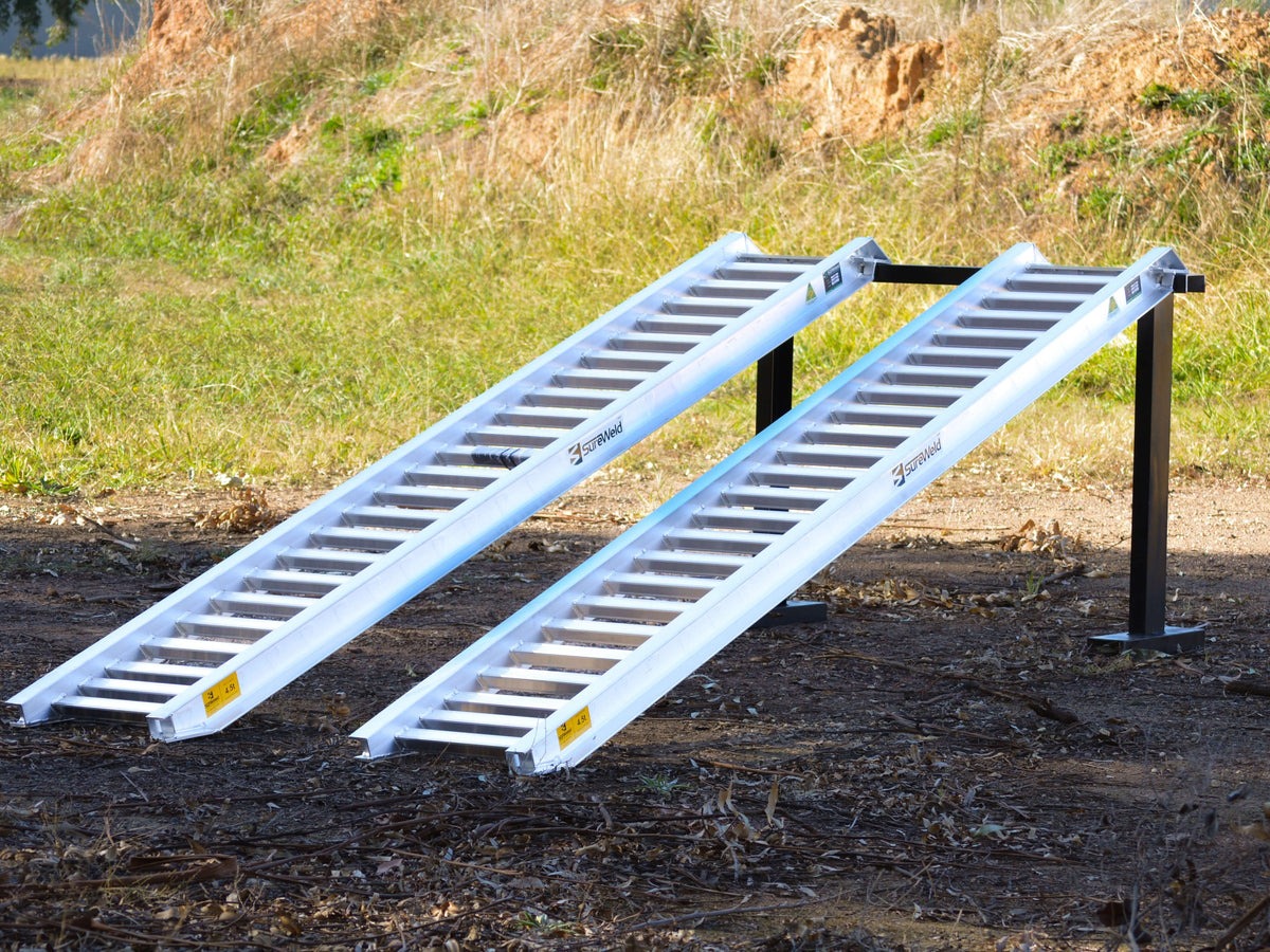 Pair of Sureweld PT Series aluminium loading ramps set up outdoors on stands