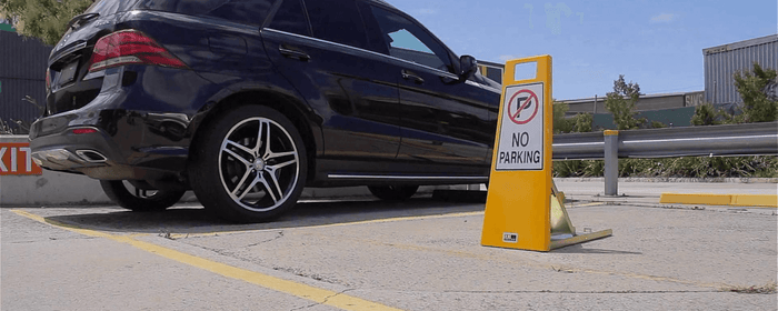Black mercedes SUV in carpark with yellow no parking sign