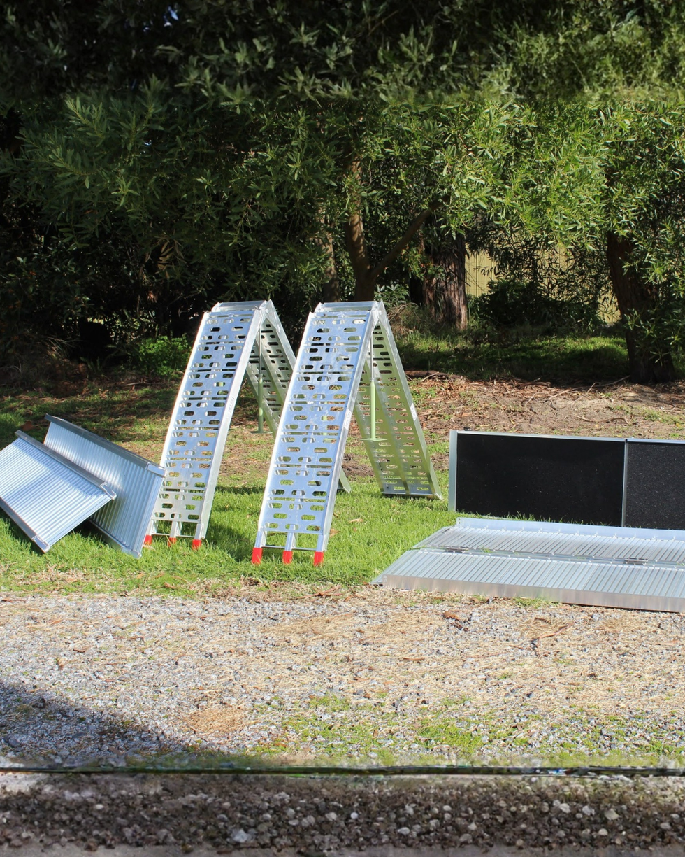 Metal ladders on grass with trees in the background