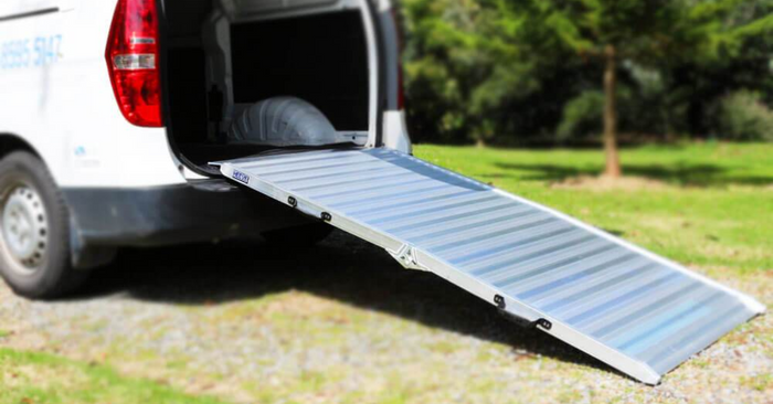 Aluminium van ramp side view against a white van outside