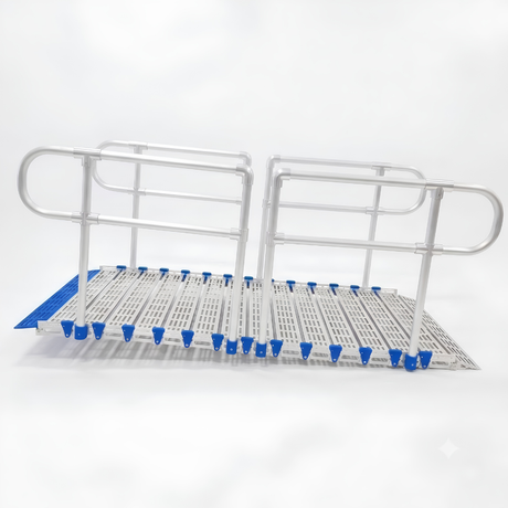 A metal rolling ramp with integrated handrails and a slotted deck plate, featuring blue protective end caps and blue grip pads, shown on a white background.