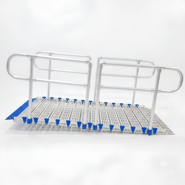 A metal rolling ramp with integrated handrails and a slotted deck plate, featuring blue protective end caps and blue grip pads, shown on a white background.