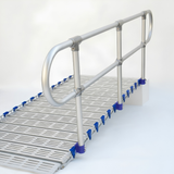 A metal walkway ramp with a slatted floor and silver handrails, shown on a clean white studio background. Blue plastic end caps are visible along the side of the ramp.