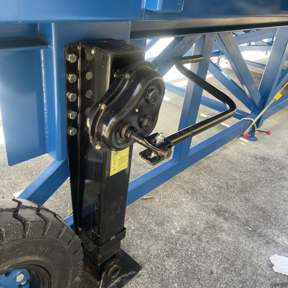 Underside of ramp showing hydraulic jack system and frame support.

