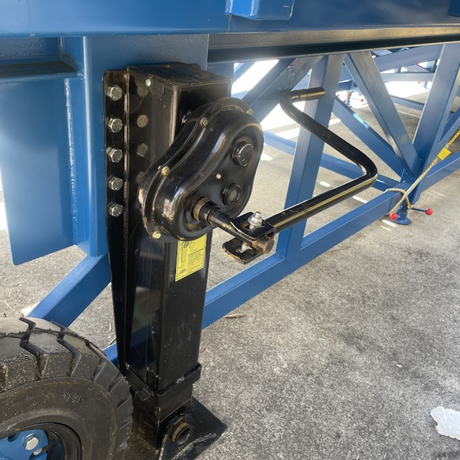 Underside of ramp showing hydraulic jack system and frame support.

