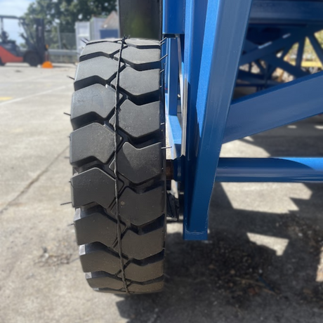 Close-up of large industrial ramp tyre and side frame on concrete
