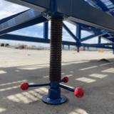 Height-adjustable support leg with threaded spindle and red handles.

