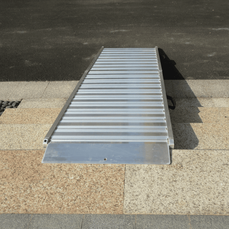 Aluminium ramp set up on kerb edge, partially elevated.