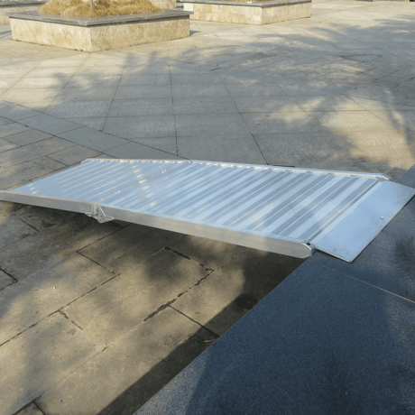 Lightweight ramp placed on outdoor path, ready for loading.

