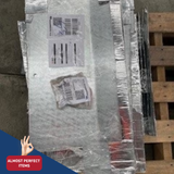 Stack of metal panels with packaging on a wooden pallet, labeled 'Almost Perfect Items'.