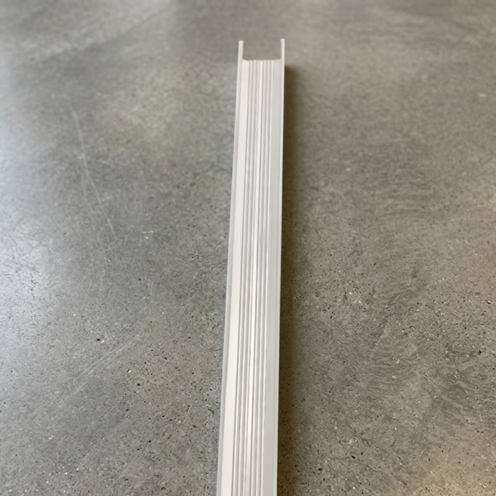 High-angle shot of a long, silver-anodized aluminium threshold ramp showing its ribbed, non-slip surface texture.