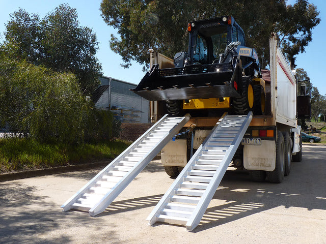Skid steer loading onto a truck with Sureweld Rubber Series aluminium loading ramps