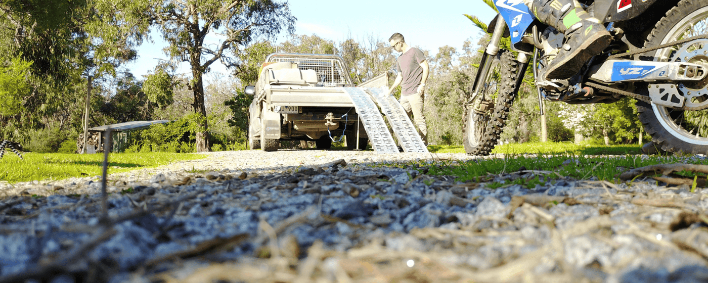 Motorcycle loading ramps against a ute