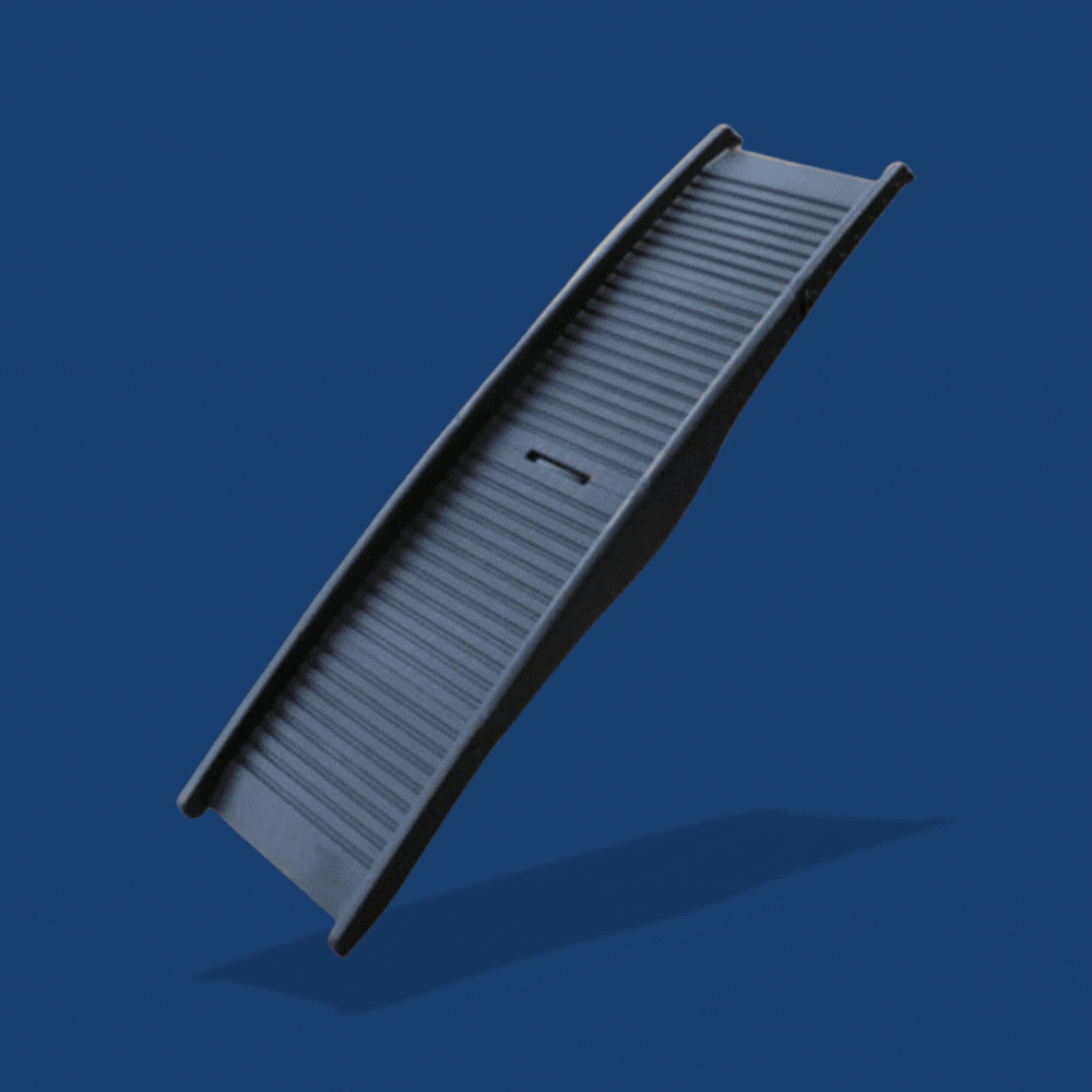 Black folding dog ramp with a ribbed surface and carry handle on a blue background.